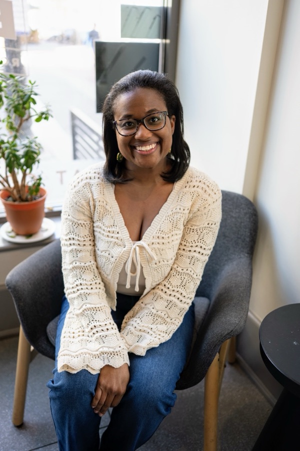 Portrait of Tiffany Carey Jones, smiling, seated indoors